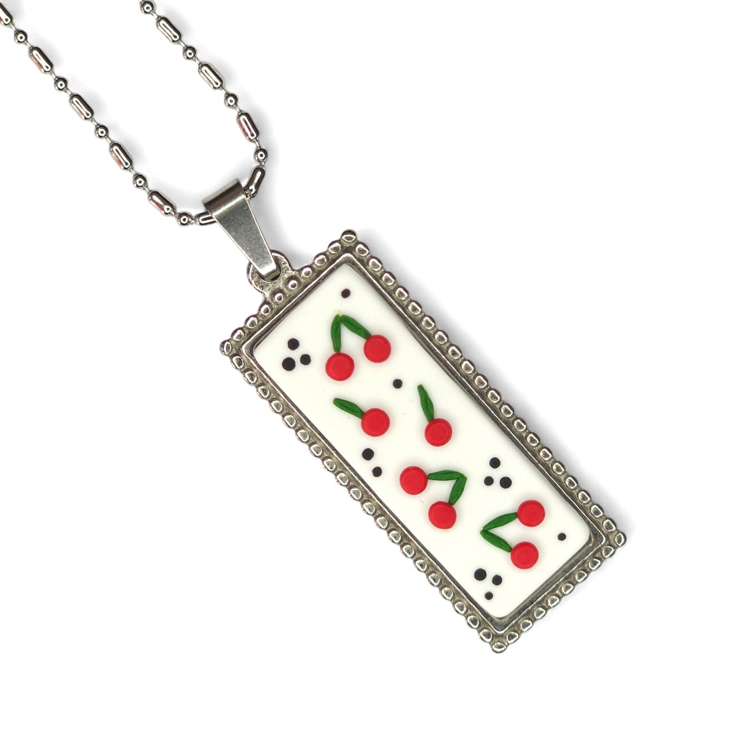 Κολιέ μακρύ με κερασάκια σε λευκό φόντο σε ατσάλινη παραλληλόγραμμη βάση
