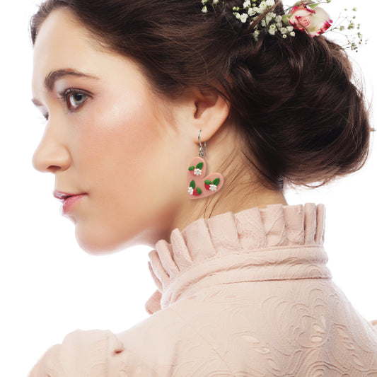 Κρεμαστά σκουλαρίκια ανόμοιες καρδιές κόκκινες φραουλίτσες σε απαλό ροζ φόντο από πολυμερικό πηλό